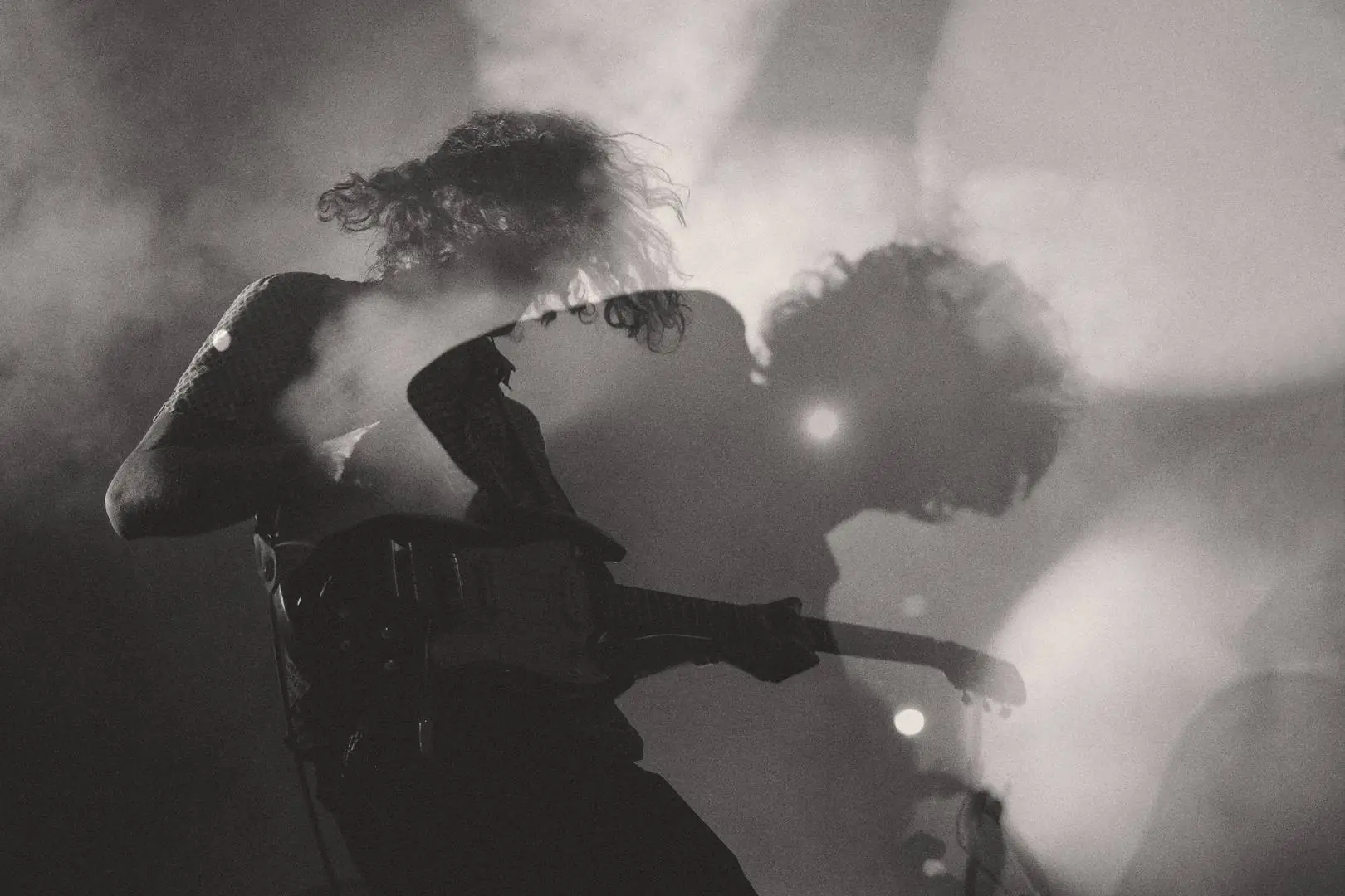 Guitarists performing in smoke